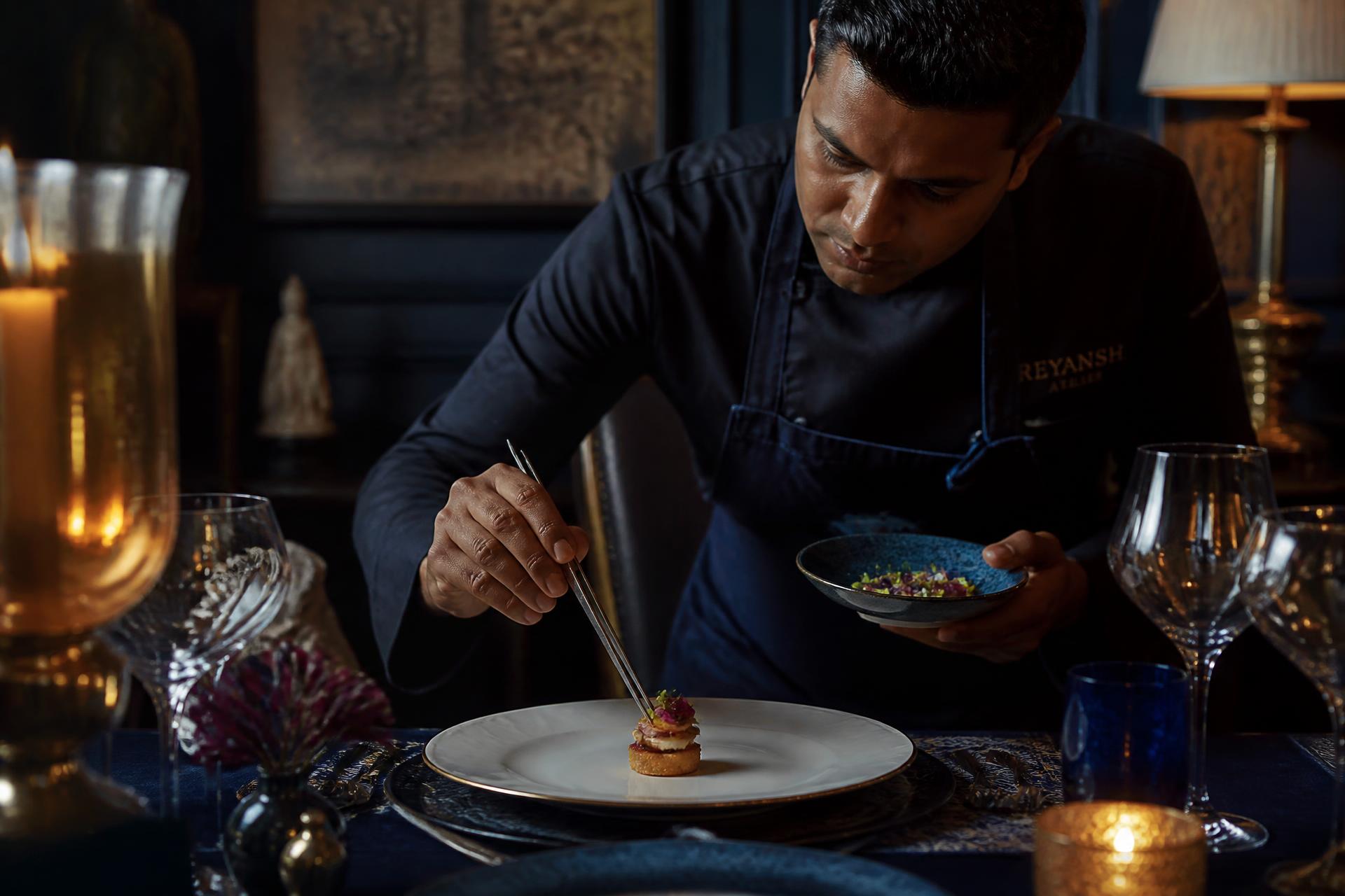 A chef plating a starter at a client's table